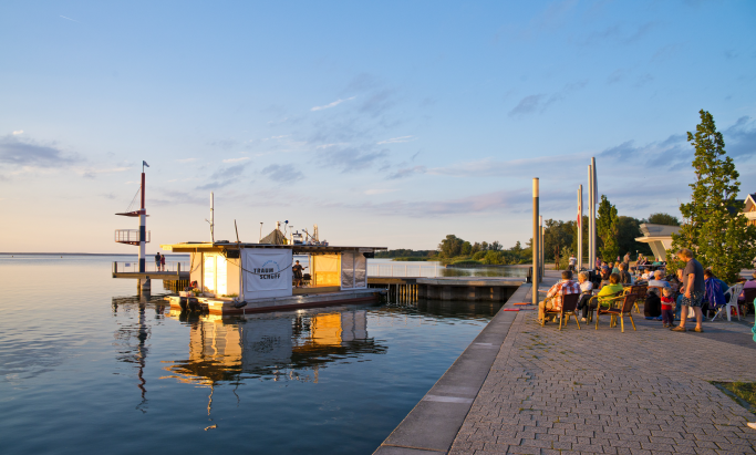 Das Theaterschiff der Traumschüff geG mit Publikum im Sonnenuntergang